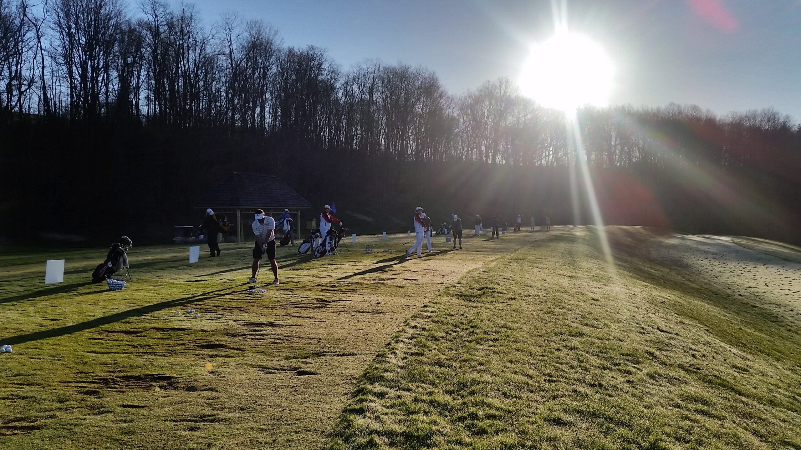 Golfers practicing on the driving range at sunrise, emphasizing focus, persistence, and the mental game.