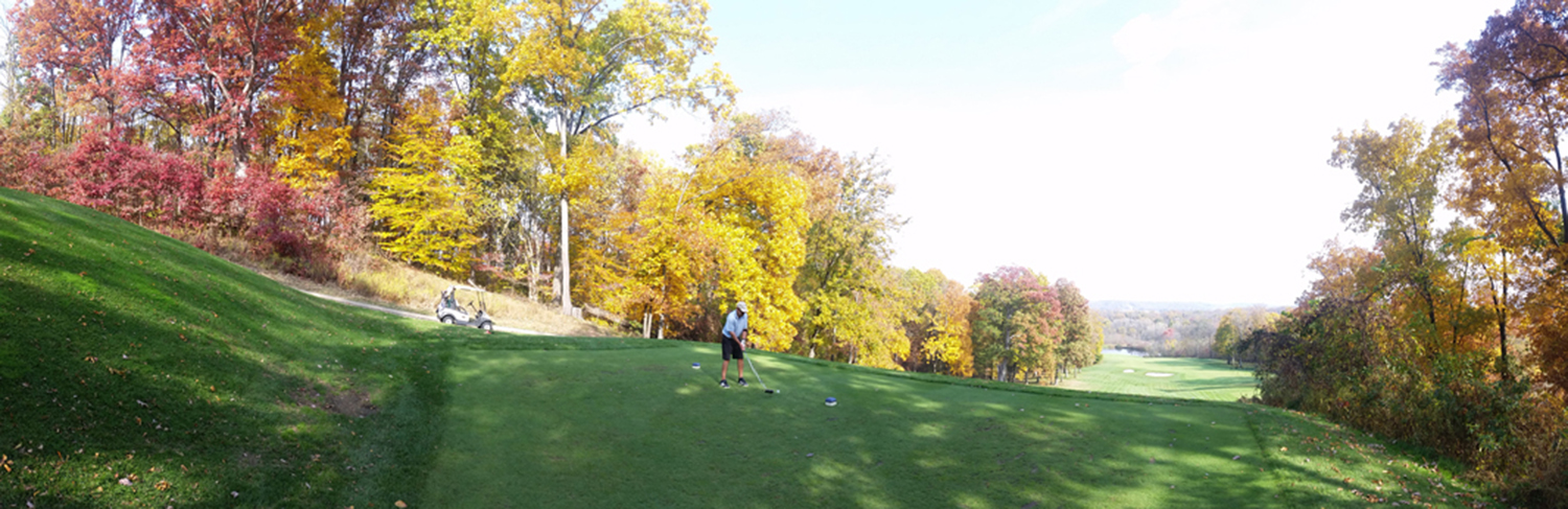 Golfer preparing to tee off on the number 4 tee box at Virtues Golf Club in autumn, surrounded by vibrant fall foliage.