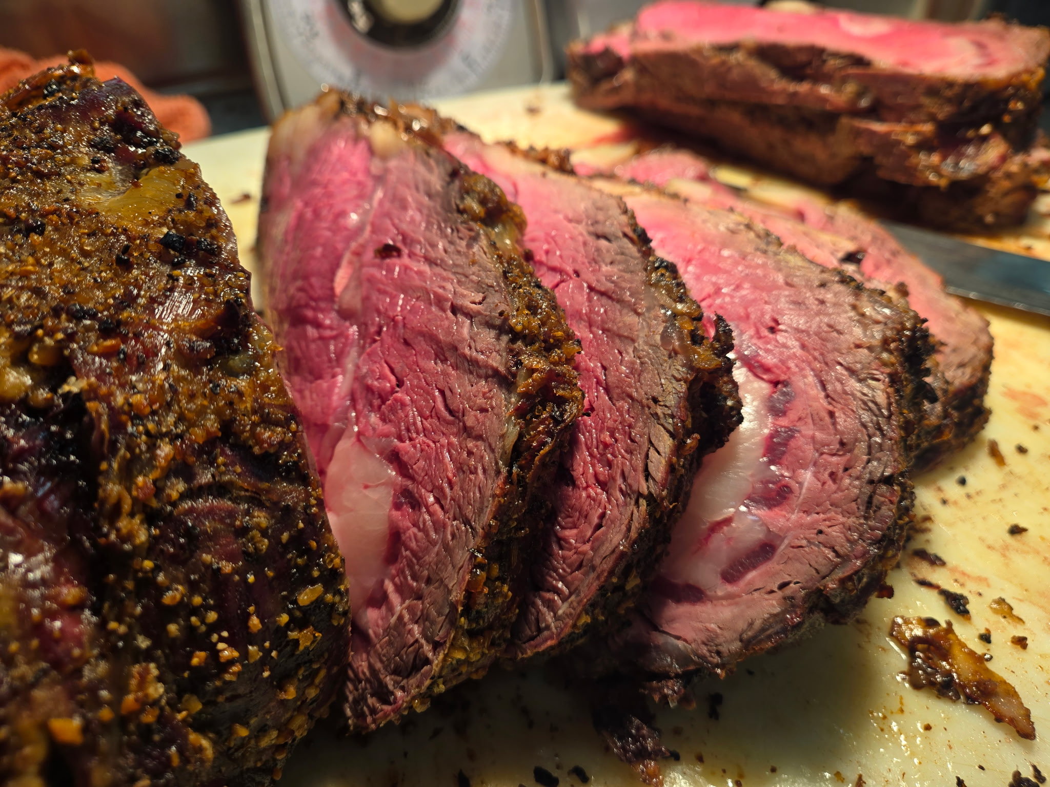 Close-up of a freshly sliced, perfectly cooked ribeye steak with a pepper-crusted edge.